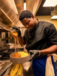Chef versant sauce sur purée en cuisine